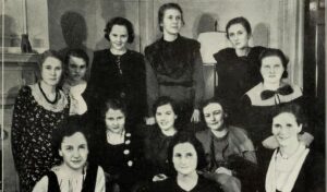 Black and white photo of a group of women looking at camera.