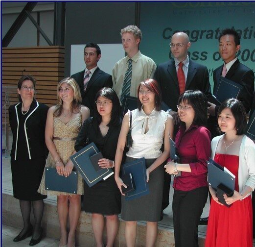 A group of students holding a certificate next to a professor.