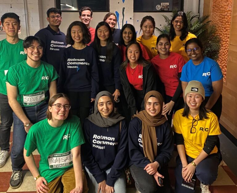 A group of people dressed in differently coloured shirts that read ‘Rotman Commerce Houses’ or ‘RC’.